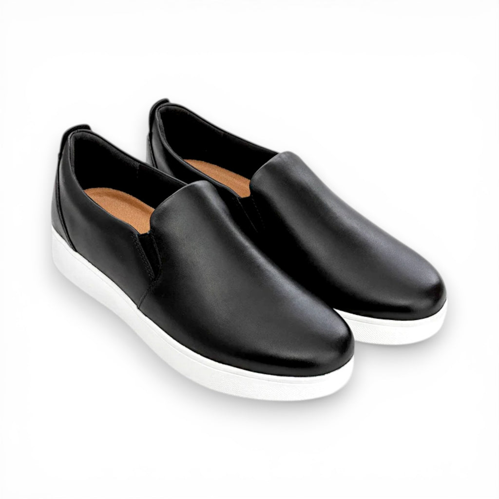 Black slip-on shoes with white soles on a white background