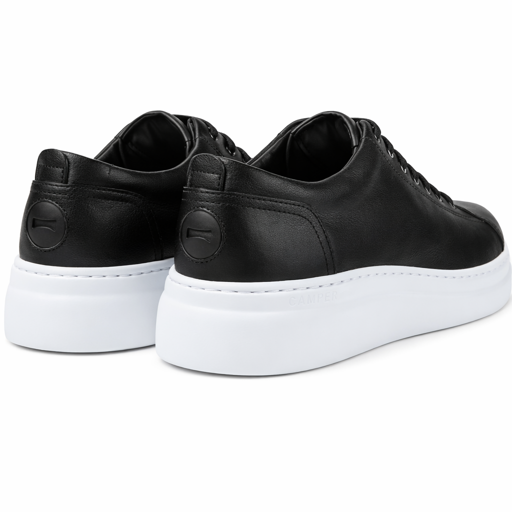 Black sneakers with white soles on a white background