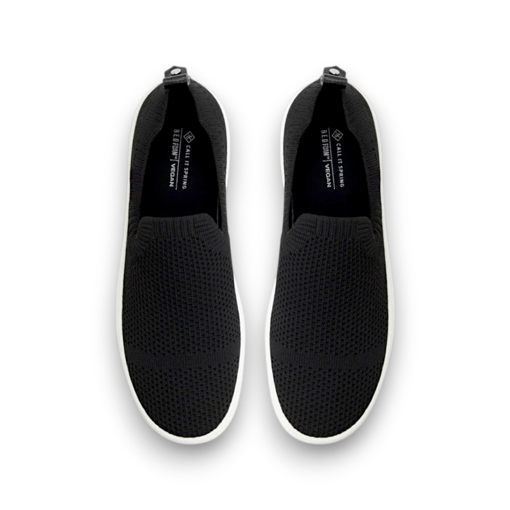 Black slip-on shoes with white soles on a white background