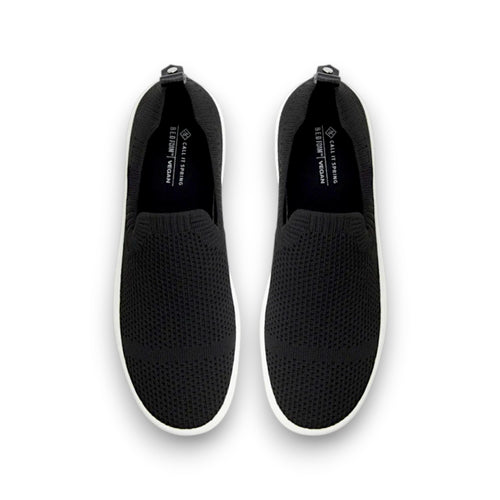 Black slip-on shoes with white soles on a white background