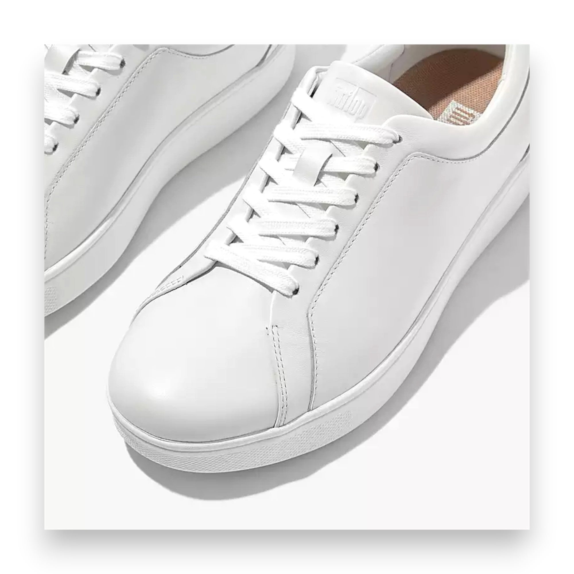 White sneakers with a brand logo on a white background